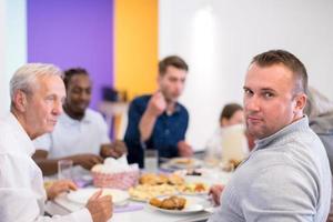 young muslim man enjoying iftar dinner with family photo