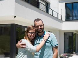 pareja abrazándose frente a una nueva casa de lujo foto