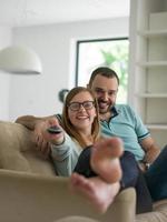 Young couple on the sofa watching television photo