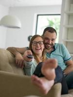 Young couple on the sofa watching television photo