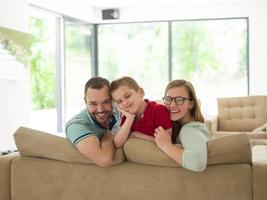 familia con niño pequeño disfruta en la sala de estar moderna foto