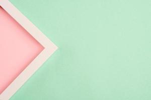 Pink triangle in a frame on a green background. Top view. Copy space photo