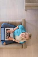 Young woman using laptop at home top view photo