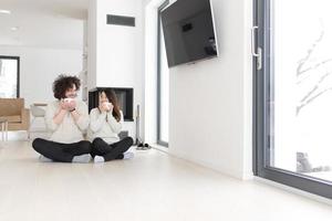 happy multiethnic couple  in front of fireplace photo