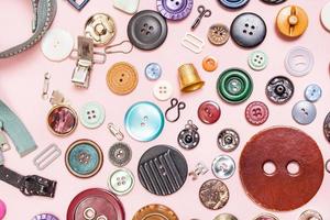 many various sewing items on pink background photo