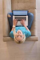 Young woman using laptop at home top view photo