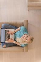 Young woman using laptop at home top view photo