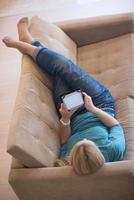 woman on sofa using tablet computer photo