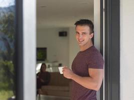 man drinking coffee in front of her luxury home villa photo