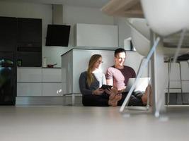 couple using tablet and laptop computers photo