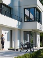 women using tablet computer in front of luxury home villa photo