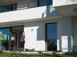 women using tablet computer in front of luxury home villa photo