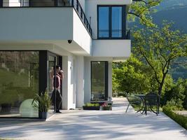 man drinking coffee in front of her luxury home villa photo