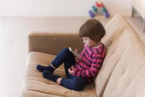 little girl playing games on smartphone photo