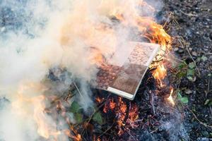 revista de comida en llamas en el fuego en la pila de rama foto