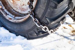 Snow chain fitted to tractor tire photo