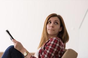 woman sitting on sofa with tablet computer photo
