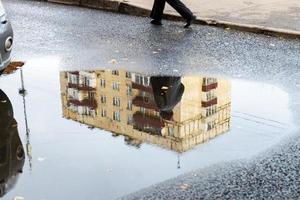 cityscape with puddle with reflection of house photo