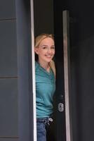 mujer abriendo la puerta de su casa foto