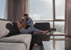 couple relaxing at  home using tablet computer photo