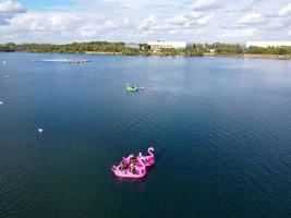 Beautiful Aerial Drone's Camera  Footage of Willen Lake and Park which is located at Milton Keynes, England. People are Enjoying at Lake on a Hot Sunny Day of Summer photo