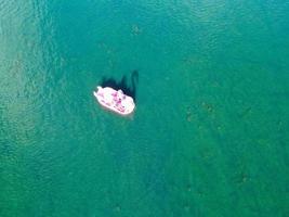 bellas imágenes de la cámara de drones aéreos del lago y parque willen que se encuentra en milton keynes, inglaterra. la gente está disfrutando en el lago en un caluroso día soleado de verano foto