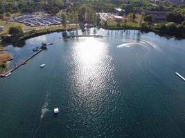 bellas imágenes de la cámara de drones aéreos del lago y parque willen que se encuentra en milton keynes, inglaterra. la gente está disfrutando en el lago en un caluroso día soleado de verano foto