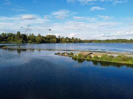 Beautiful Aerial Drone's Camera  Footage of Willen Lake and Park which is located at Milton Keynes, England. People are Enjoying at Lake on a Hot Sunny Day of Summer photo