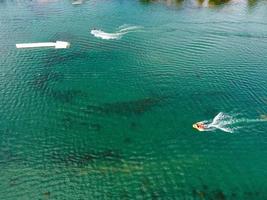 Beautiful Aerial Drone's Camera  Footage of Willen Lake and Park which is located at Milton Keynes, England. People are Enjoying at Lake on a Hot Sunny Day of Summer photo