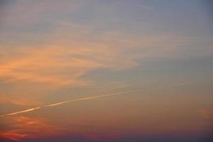 hermosa luz del atardecer y nubes y un rastro del avión. paisaje de puesta de sol de noche en verano. foto