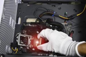 Image of a technician inserting a CPU chip onto a computer motherboard. photo