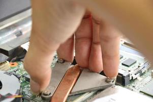 Close-up of the hand about to put the device on the motherboard. photo