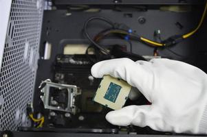 Image of a technician inserting a CPU chip onto a computer motherboard. photo