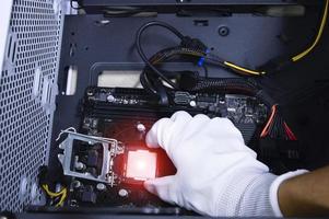 Technician is inserting a CPU chip on a computer motherboard. photo