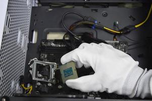 Image of a technician inserting a CPU chip onto a computer motherboard. photo