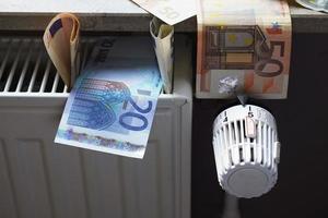 billetes en euros en el radiador como concepto para el aumento de los costes de calefacción y la crisis del precio del gas foto
