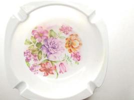 white cigarette ashtray with floral motif in the middle. ashtray isolated on a white background.  Ashtrays are often used by smokers to dispose of cigarette ashes or cigarette butts photo