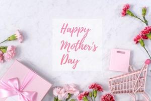 Happy Mother's Day background design concept with greeting words, beautiful pink, red carnation flower bouquet on marble table, top view, flat lay, copy space. photo