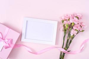 día de la madre, concepto de diseño de fondo del día de San Valentín, hermoso ramo de flores de clavel rosa en una mesa rosa pastel, vista superior, puesta plana, espacio para copiar. foto