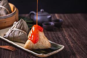 Zongzi - Chinese rice dumpling zongzi in a steamer on wooden table black retro background for Dragon Boat Festival celebration, close up, copy space. photo