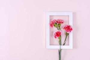 Mother's Day, Valentine's Day background design concept, beautiful pink, red carnation flower bouquet on pink table, top view, flat lay, copy space. photo