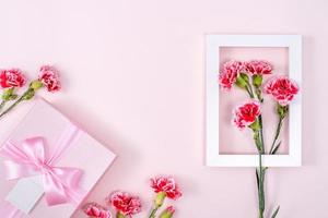 Mother's Day, Valentine's Day background design concept, beautiful pink, red carnation flower bouquet on pink table, top view, flat lay, copy space. photo