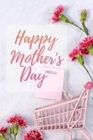 Happy Mother's Day background design concept with greeting words, beautiful pink, red carnation flower bouquet on marble table, top view, flat lay, copy space. photo