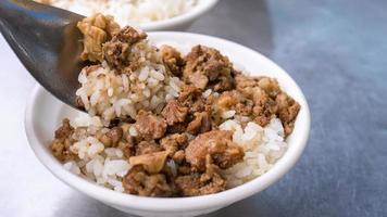 Braised meat rice, stewed beef over cooked rice in Tainan, Taiwan. Taiwanese famous traditional street food delicacy. Travel design concept, closeup.