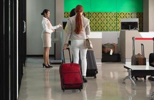 Passengers waiting in queue at airline check in counter in airport photo