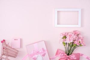 día de la madre, concepto de diseño de fondo del día de San Valentín, hermoso ramo de flores de clavel rosa en una mesa rosa pastel, vista superior, puesta plana, espacio para copiar. foto