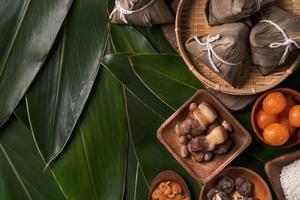 Rice dumpling, zongzi - Traditional Chinese food on green leaf background of Dragon Boat Festival, Duanwu Festival, top view, flat lay design concept. photo