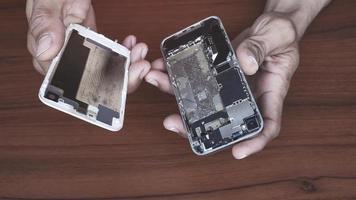 manos de un técnico que sostiene parte del cuerpo de un teléfono para reparar el teléfono celular o reparar la batería y reemplazar el sistema de reparación del teléfono inteligente. foto