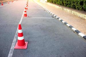 cono de tráfico con líneas de estacionamiento en asfalto foto