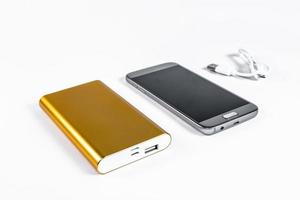 Golden powerbank with smart phone on background photo